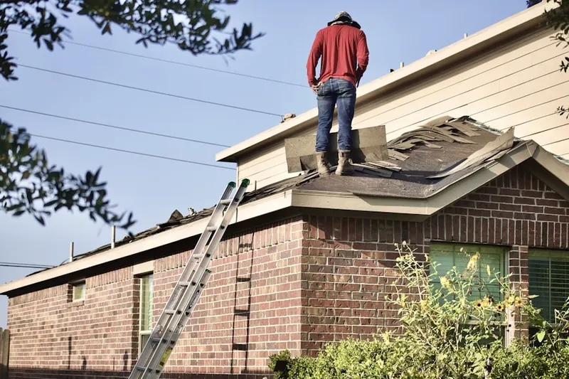 Professional roofer working on a residential roof in Plimptonville